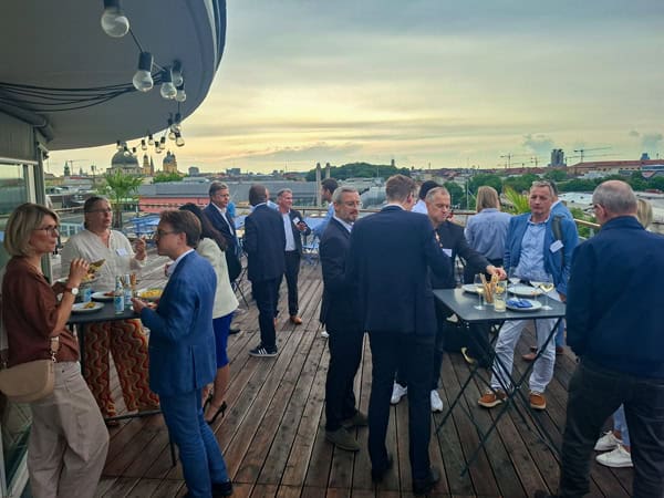 Ausklang bei Out of Office 2026 auf der Dachterrasse mit Gesprächen, Pinsa und Blick über München.